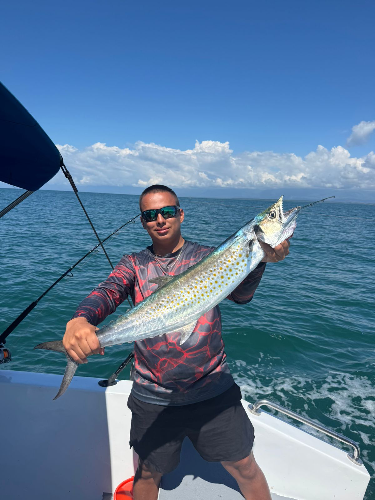 Angler holding a large sierra mackerel offshore