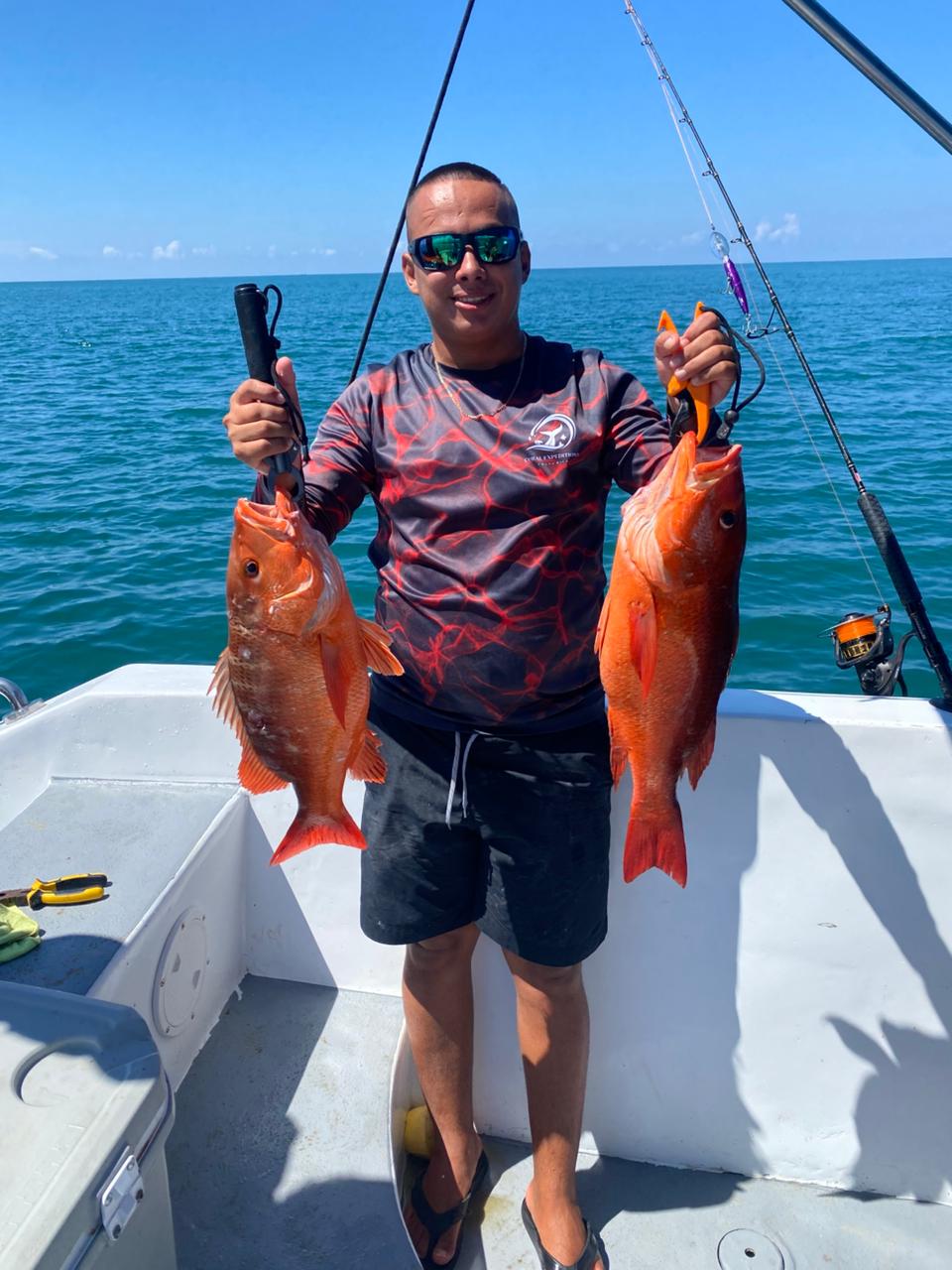 Angler holding two red snappers