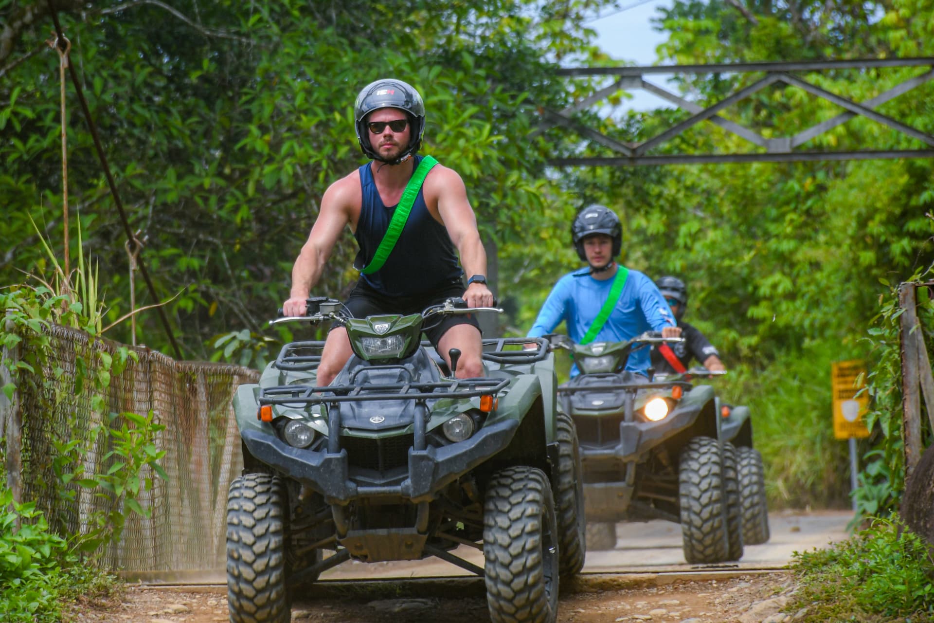 ATV riders crossing a suspension bridge