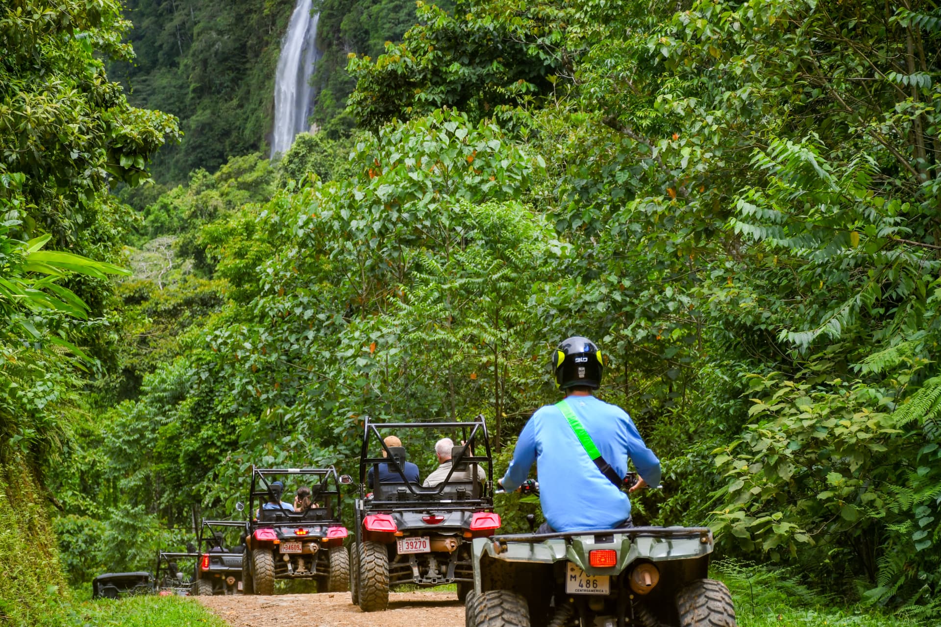 ATVs and side-by-sides approaching a jungle waterfall
